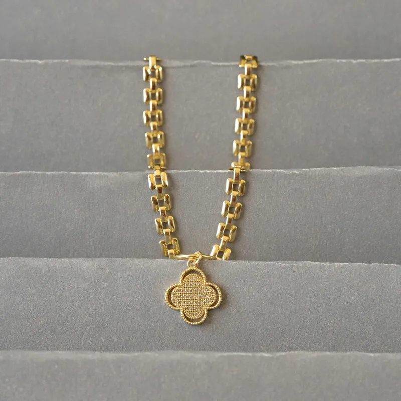 A necklace with a four leaf clover pendant on a gold chain