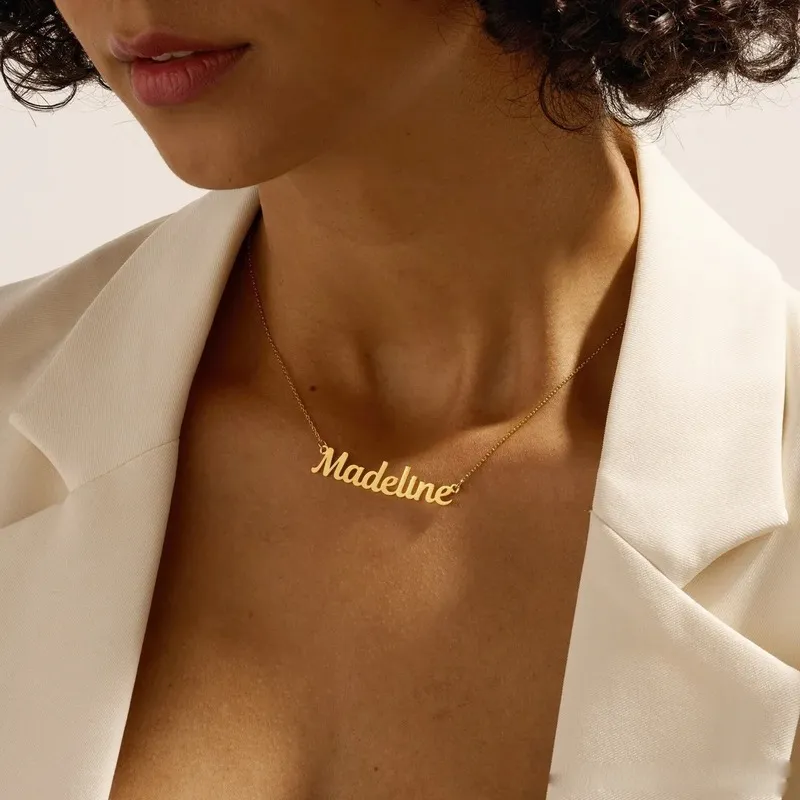 Name necklace worn by person in white blazer