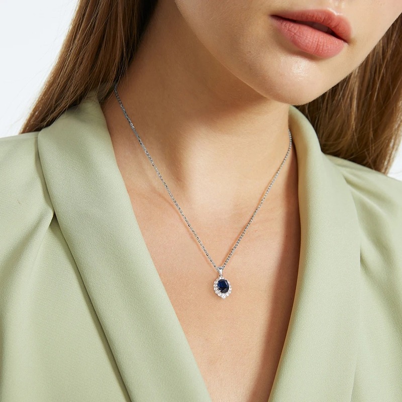 Sapphire necklace worn by person in green top